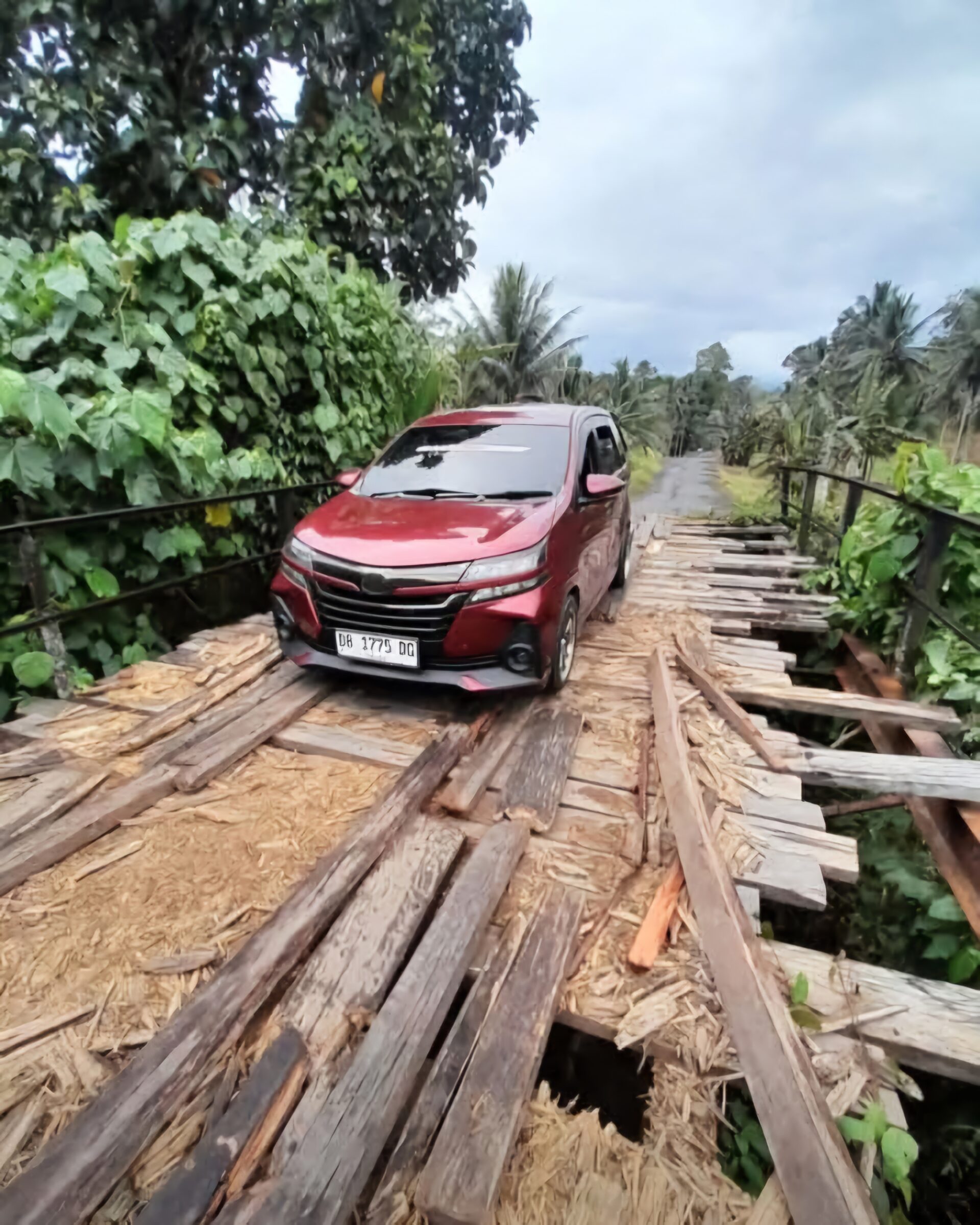 Kendaraan melintas di jembatan kayu rusak menuju Desa Serasi Kabupaten Bolaang Mongondow mediasulut.id