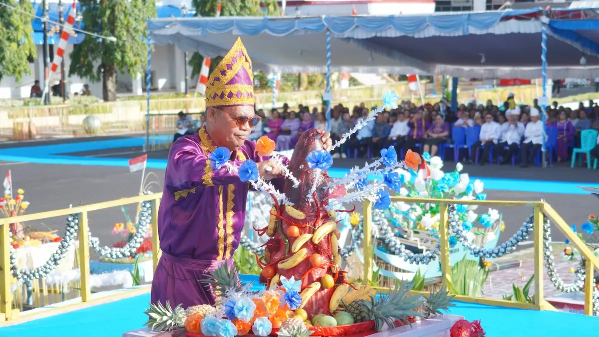 Prosesi pemotongan kue adat Tamo sebagai simbol syukur dalam Upacara Adat Tulude Kota Bitung 2026 mediasulut.id