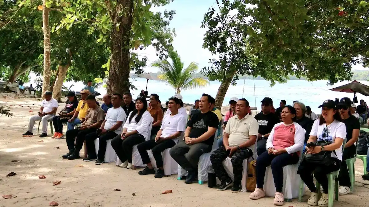 Rombongan pejabat Pemkab Talaud dan TNI duduk bersama di pantai Pulau Sara