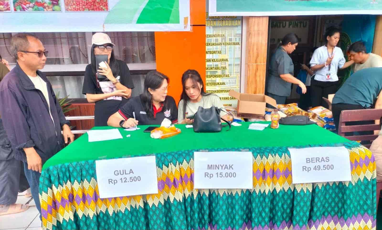 Petugas Pemkab Minahasa melayani warga pada gerakan pangan murah di Tondano