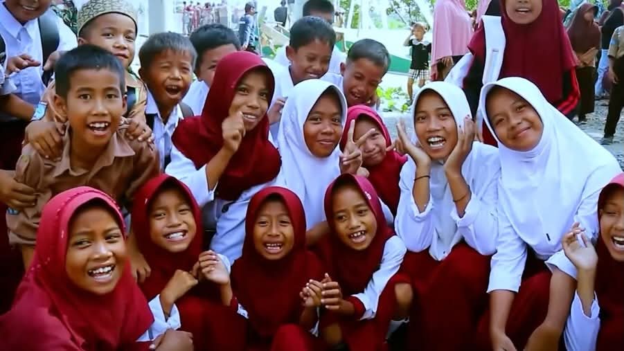 anak-anak sekolah dasar tersenyum bersama di lingkungan sekolah indonesia