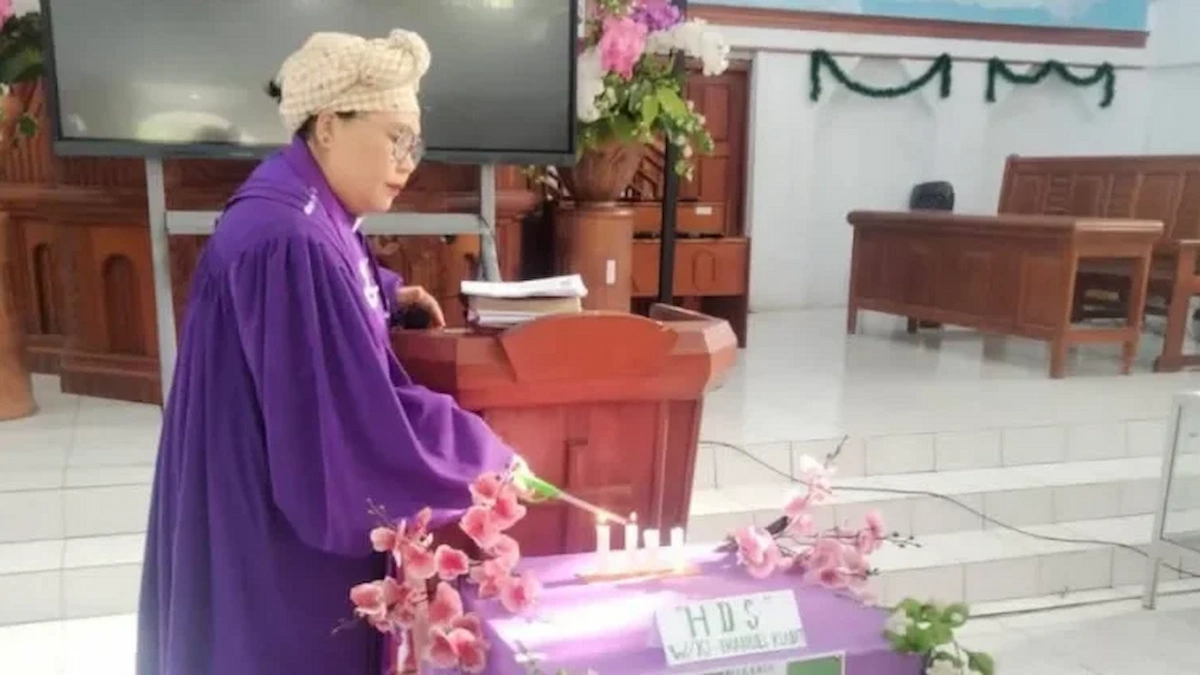 Pendeta menyalakan lilin HDS di GMIM Imanuel Klabat Tatelu