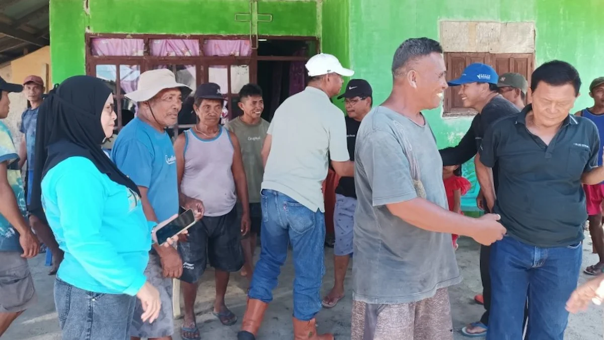 Oskar Manoppo berbincang dengan warga setelah kegiatan tanggul darurat abrasi pantai boltim