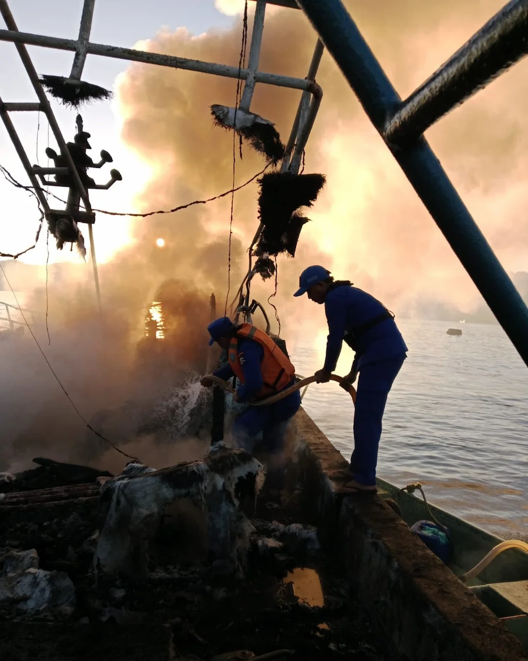 Petugas memadamkan kebakaran kapal di Selat Lembeh Bitung