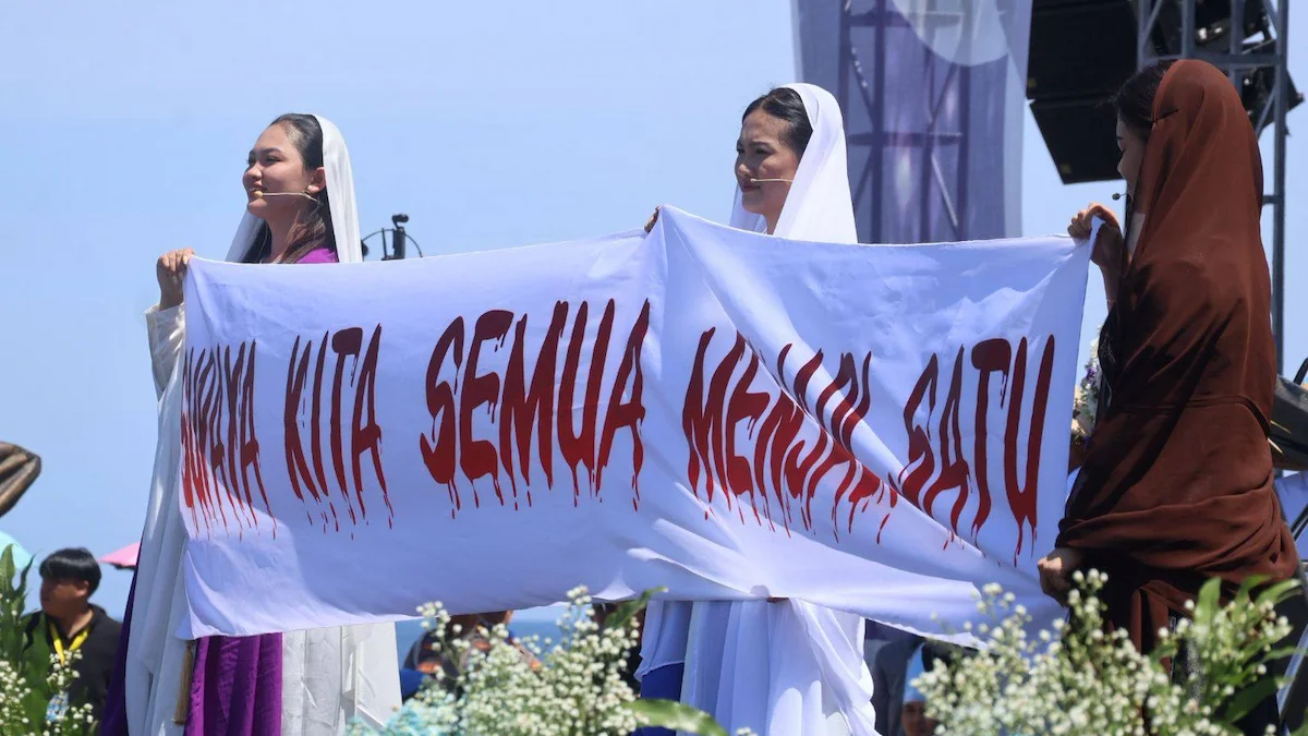 Penampilan teatrikal jemaat wanita memegang spanduk 'Supaya Kita Semua Menjadi Satu' di Paskah Nasional Manado.