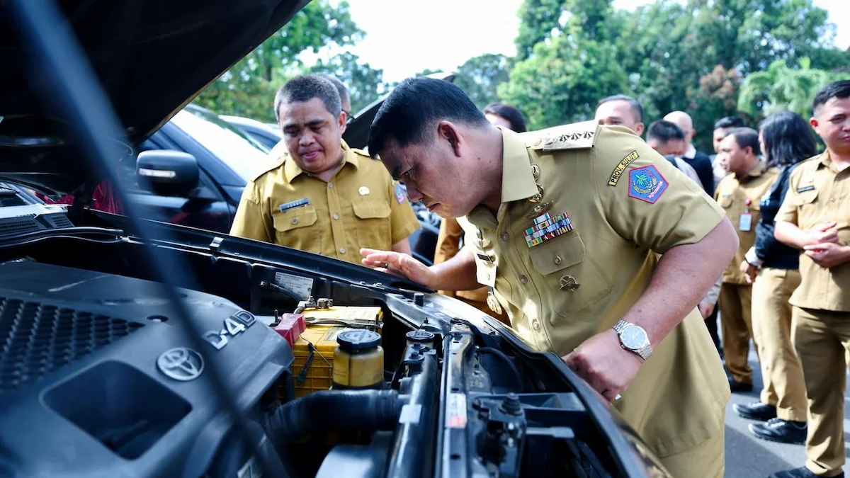 Yulius Selvanus memeriksa kondisi mesin mobil saat audit kendaraan dinas Sulawesi Utara