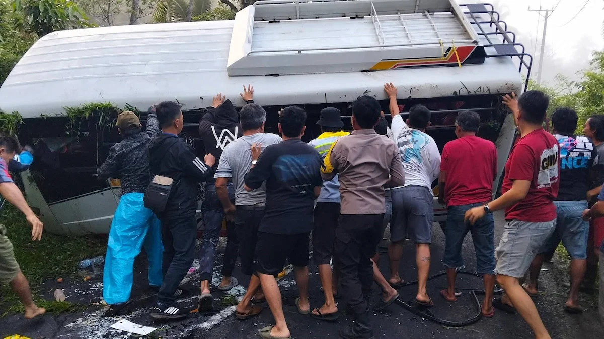 Warga membantu evakuasi bus rombongan WKI GMIM yang terguling di Minahasa Selatan