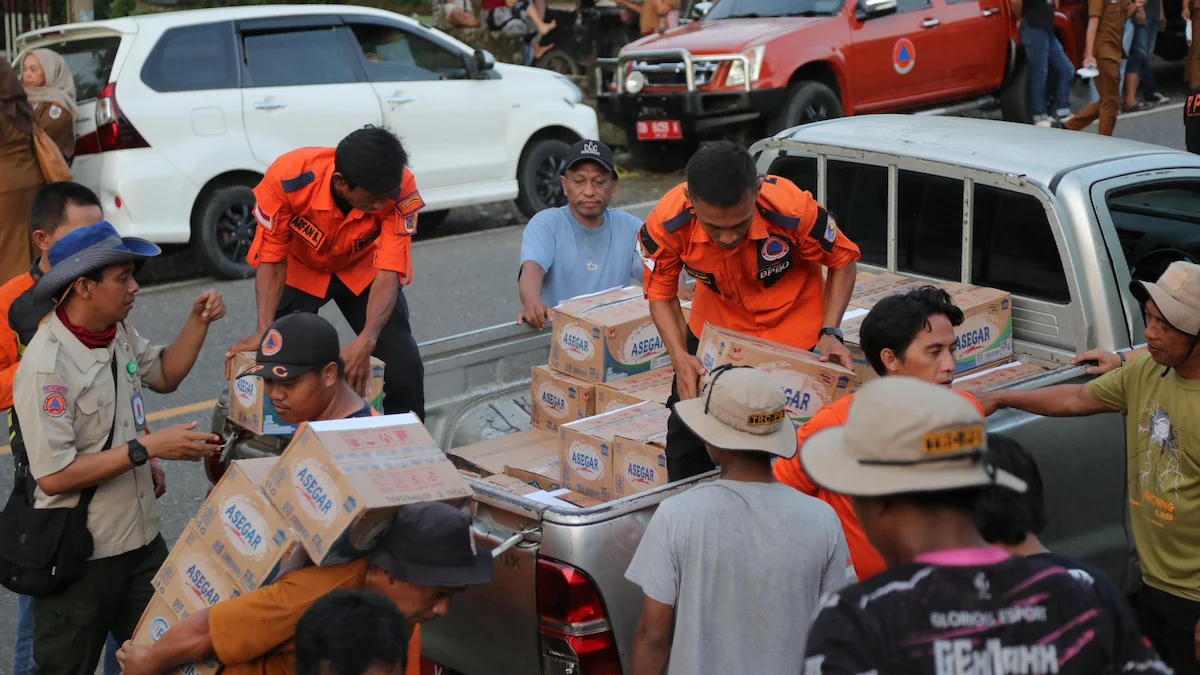 Petugas BPBD dan relawan membagikan bantuan logistik dari Pemkot Kotamobagu kepada korban banjir bandang di Bolaang Mongondow